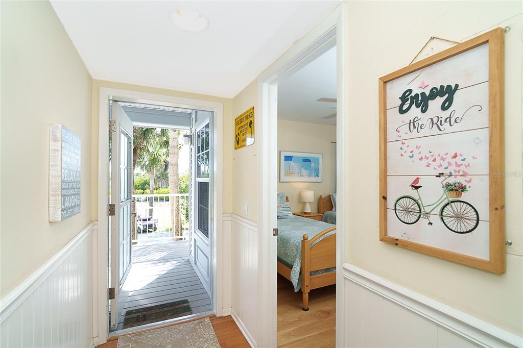 A hallway leads to an open door revealing a balcony and an adjacent bedroom — 7438 PALM ISLAND DRIVE UNIT 3712, PLACIDA, FL