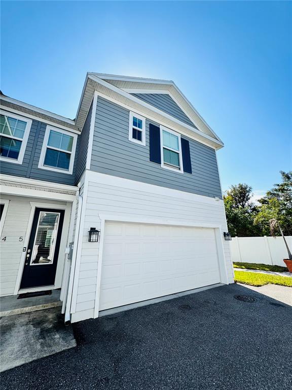 A two-story townhouse exterior features blue and white siding, a garage, and a front door — 6617 S MANHATTAN AVENUE UNIT 5, TAMPA, FL
