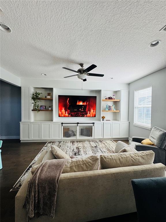 A living room features a large built-in media center with shelving and a dog crate — 6617 S MANHATTAN AVENUE UNIT 5, TAMPA, FL