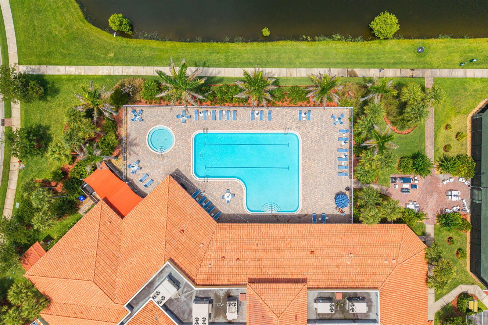 An aerial view shows a swimming pool, hot tub, and patio area beside a building — 6223 Dorchester Way, Vero Beach FL 32966, VERO BEACH, FL