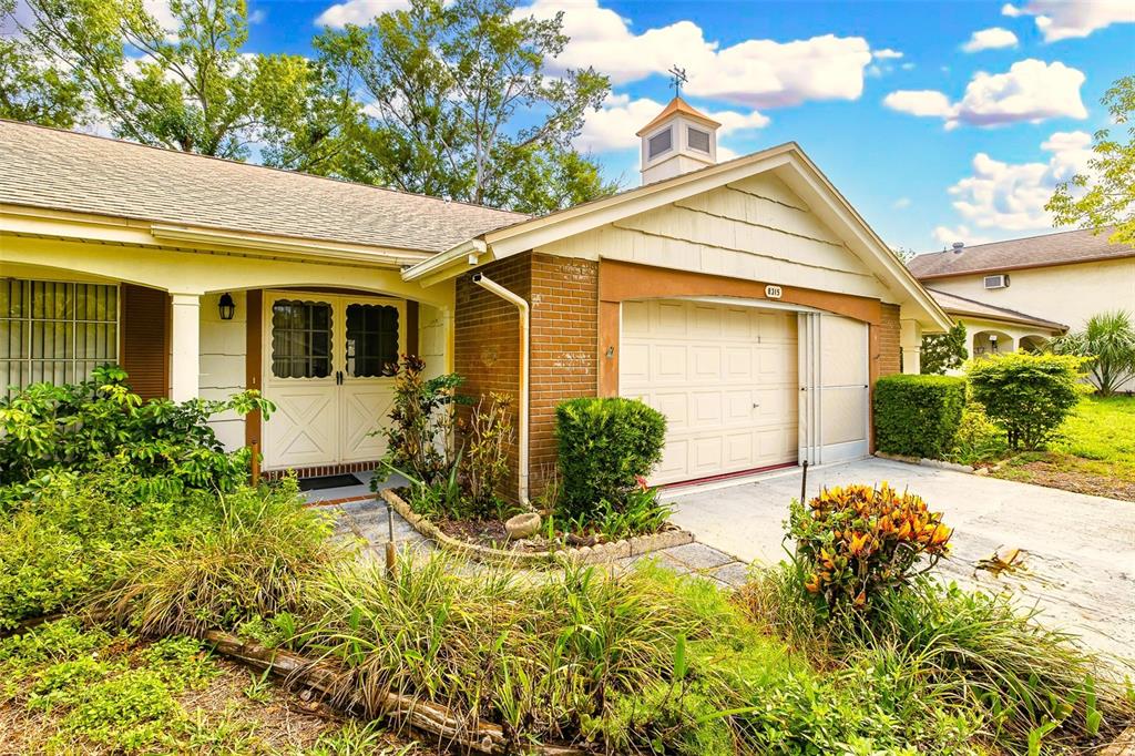 A single-story house exterior features a brick-faced garage, a cupola, and a front walkway — 8315 CAVALRY DRIVE, HUDSON, FL