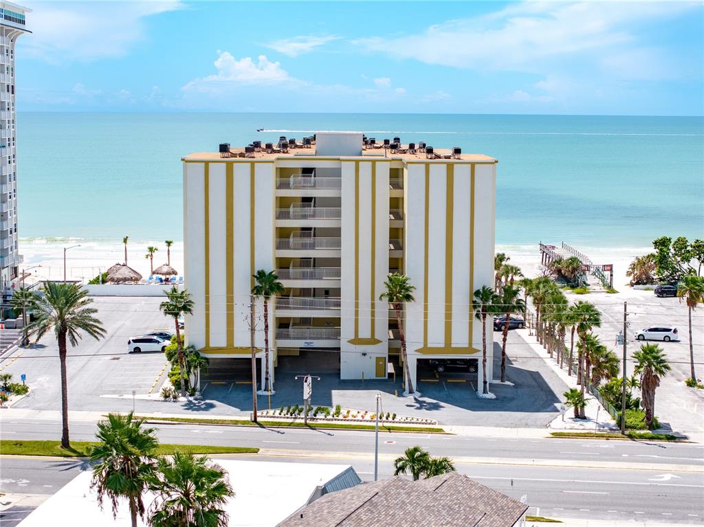 An exterior view of a multi-story beachfront apartment building with a central open-air stairwell — 17450 GULF BOULEVARD UNIT 206, REDINGTON SHORES, FL