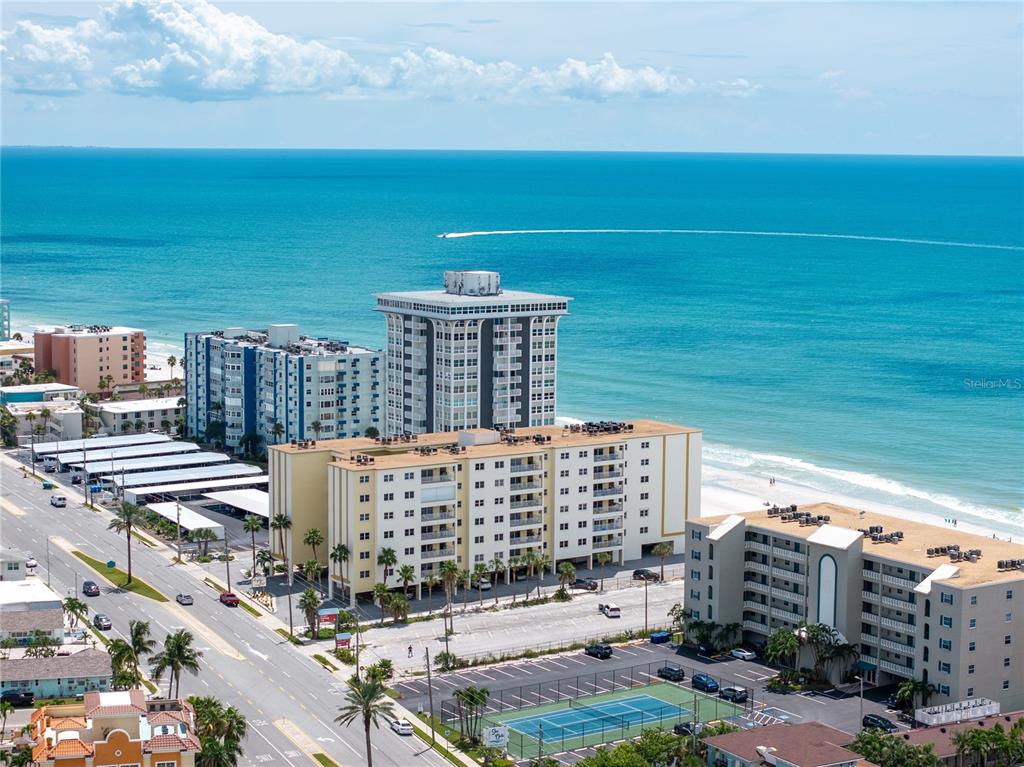 An aerial view shows several multi-story apartment buildings located along a sandy beach and ocean — 17450 GULF BOULEVARD UNIT 206, REDINGTON SHORES, FL
