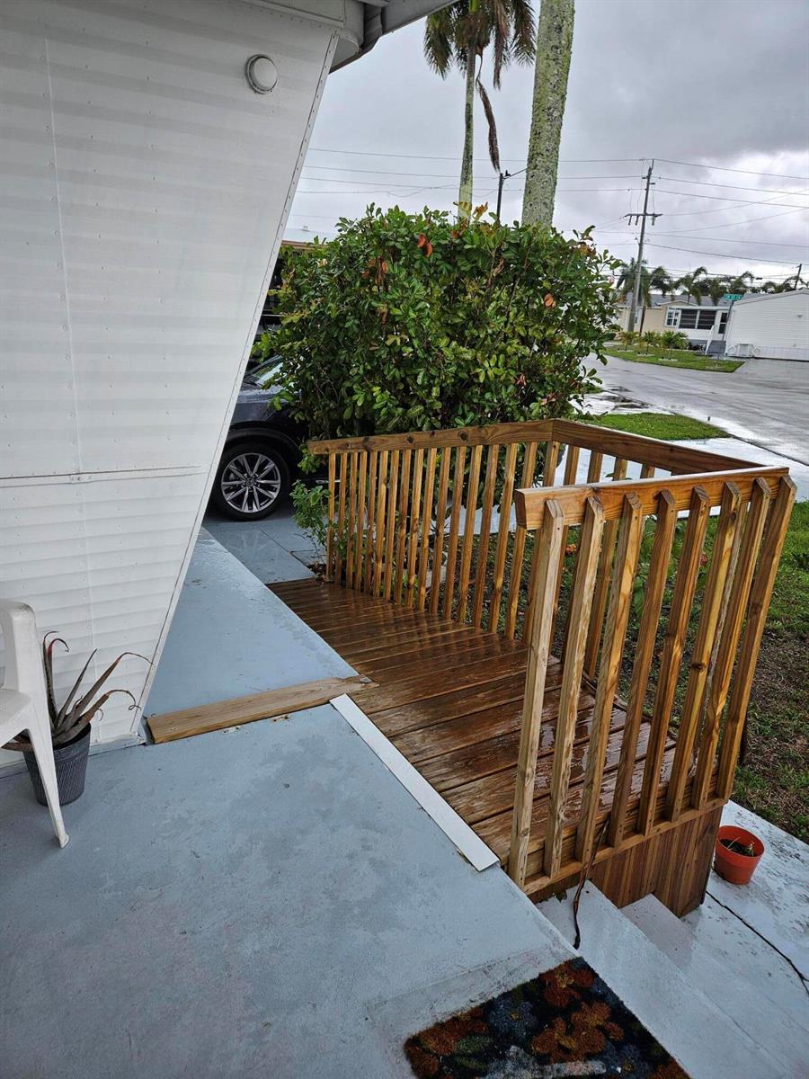 A wooden ramp with railings leads from a concrete porch to a driveway — 8550 SW 20th Street, Davie FL 33324, DAVIE, FL