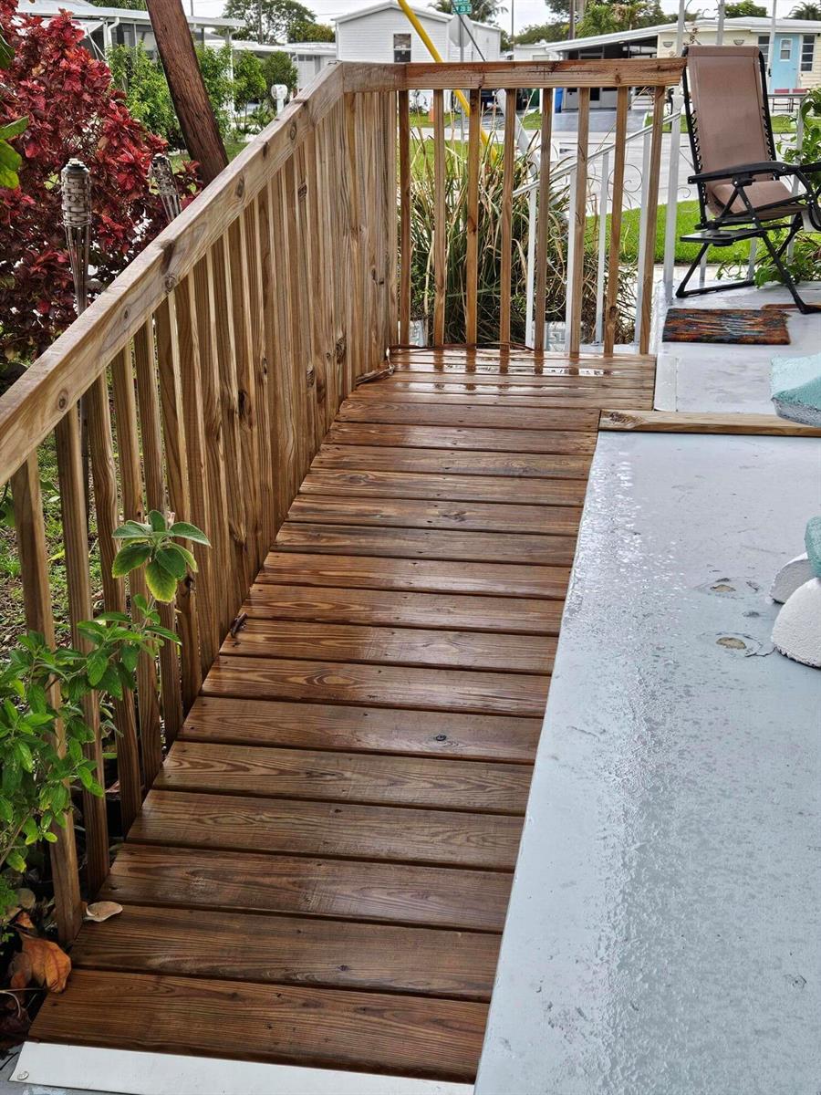 A wooden ramp with railings leads from a concrete patio toward a residential yard — 8550 SW 20th Street, Davie FL 33324, DAVIE, FL