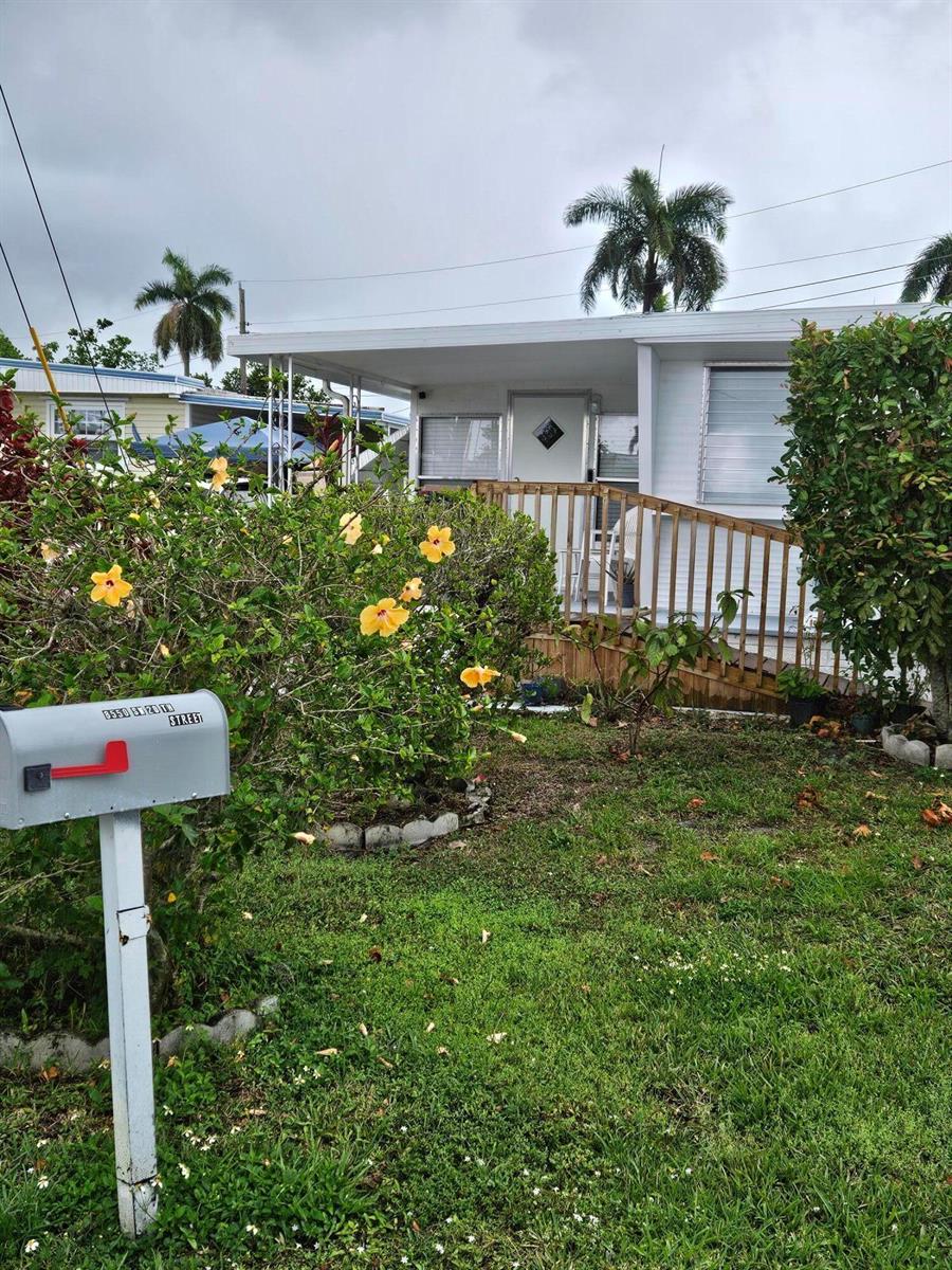 A single-story mobile home features a wooden ramp leading to the front entrance — 8550 SW 20th Street, Davie FL 33324, DAVIE, FL