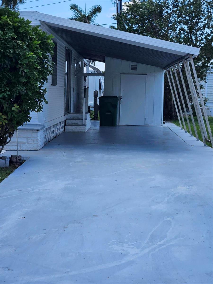 A mobile home exterior features a concrete driveway, a covered carport, and a storage shed — 8550 SW 20th Street, Davie FL 33324, DAVIE, FL