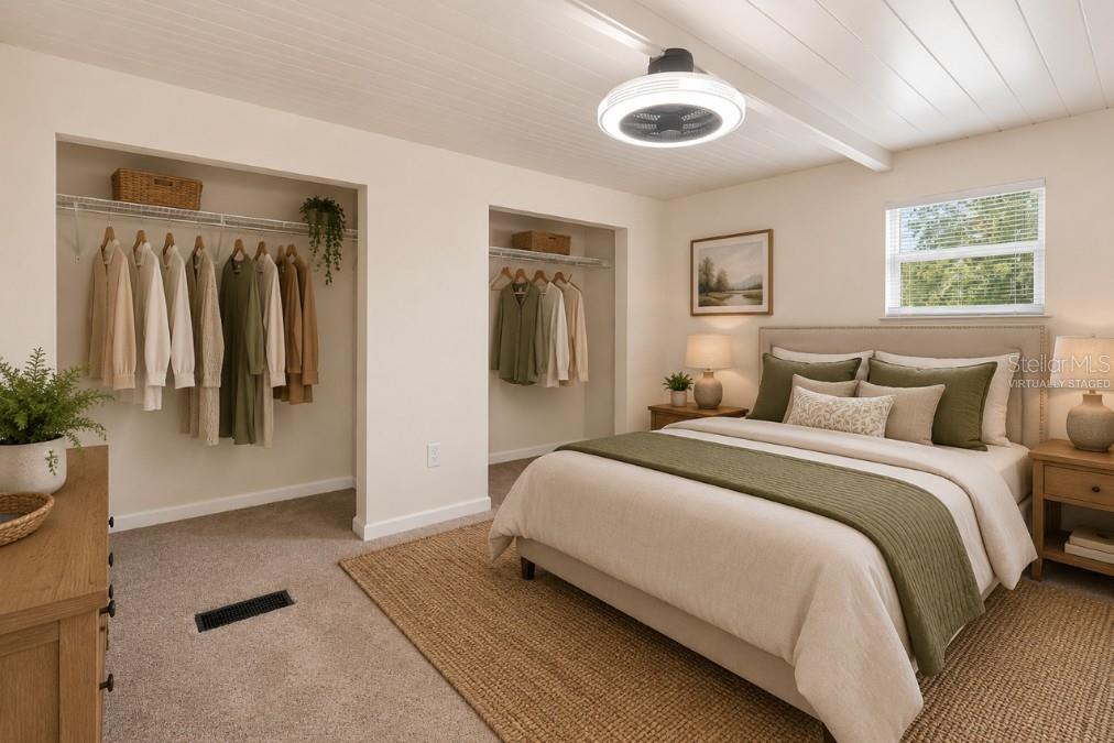 This bedroom features a bed, two open closets, a ceiling fan, and a window — 16137 LAUDERDALE STREET, BROOKSVILLE, FL