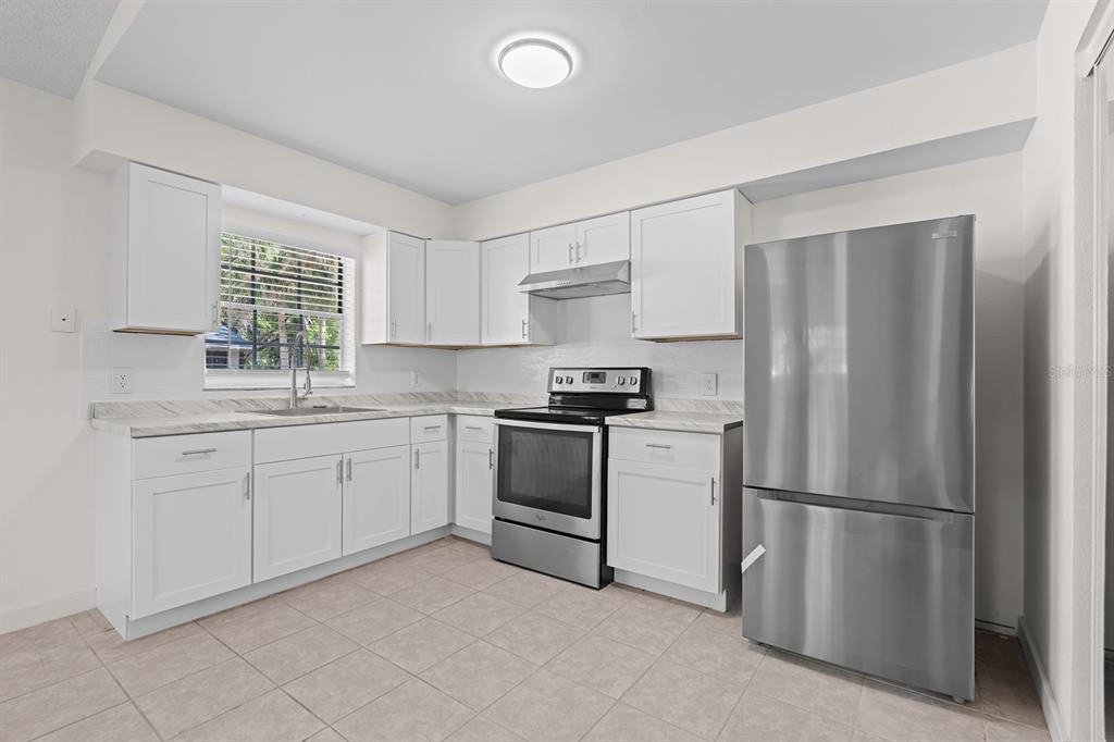 A kitchen with white cabinets, stainless steel appliances, and light-colored countertops — 452 N ELMWOOD POINT, CRYSTAL RIVER, FL