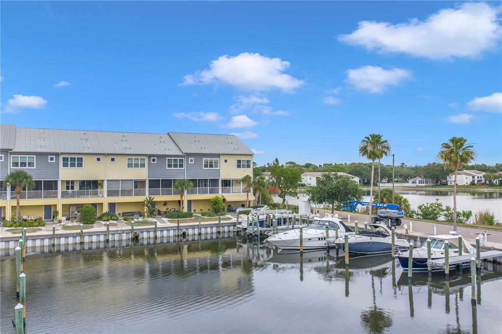A multi-story waterfront townhouse complex features private boat slips and a canal view — 6149 ANCHORAGE WAY S, ST PETERSBURG, FL