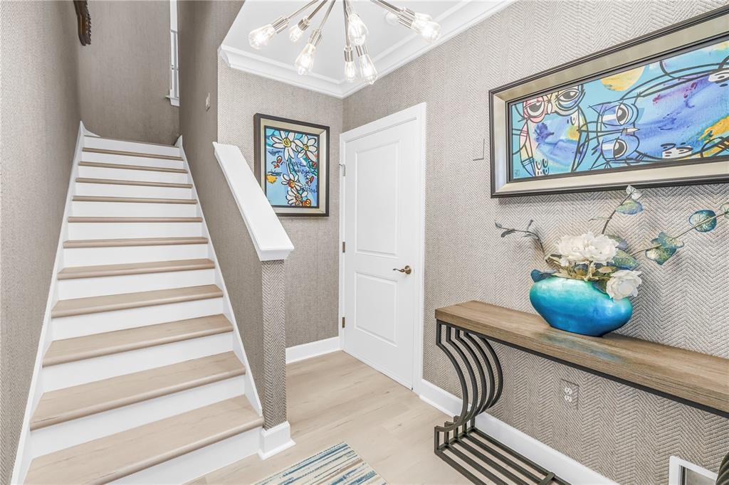 A foyer features a staircase, a console table, artwork, and textured wallpaper — 6149 ANCHORAGE WAY S, ST PETERSBURG, FL