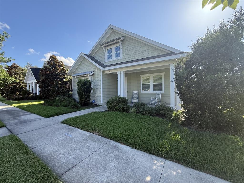 A light green house with a front porch and a sidewalk in the foreground — 636 SW 128TH TERRACE, NEWBERRY, FL
