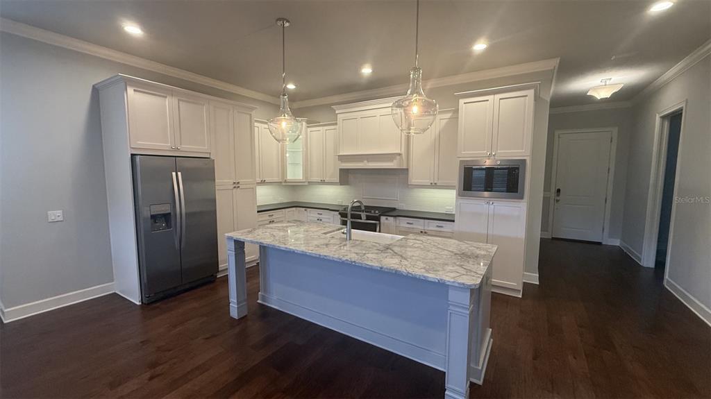 A kitchen with white cabinets, a marble-topped island, and dark hardwood floors — 636 SW 128TH TERRACE, NEWBERRY, FL