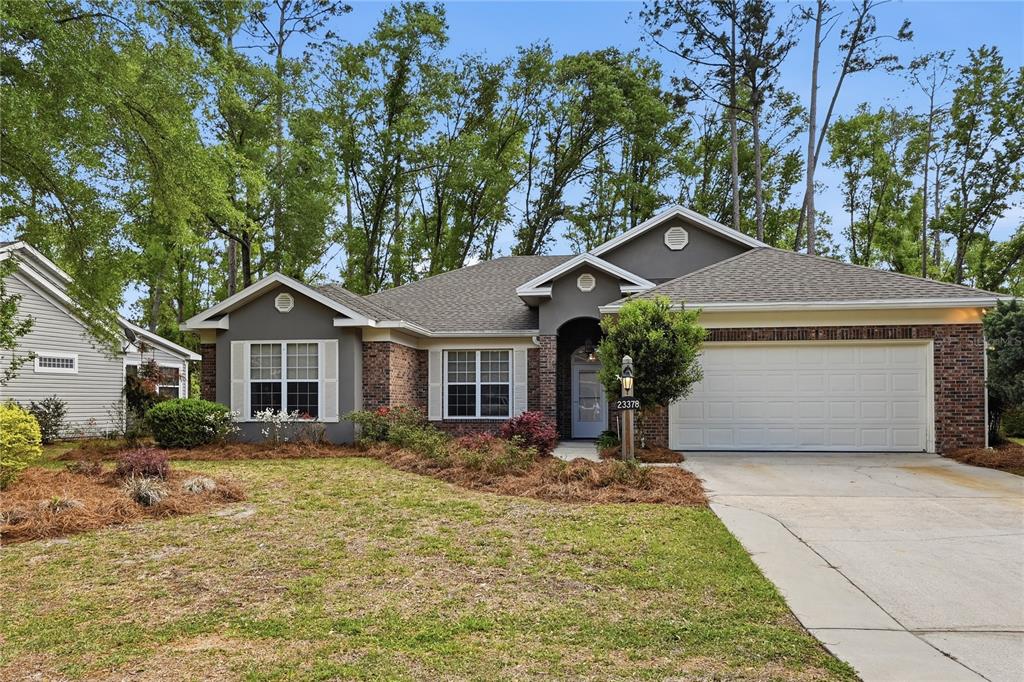 A single-story brick and gray siding house features a two-car garage and front lawn — 23378 LIVE OAK LANE, LIVE OAK, FL