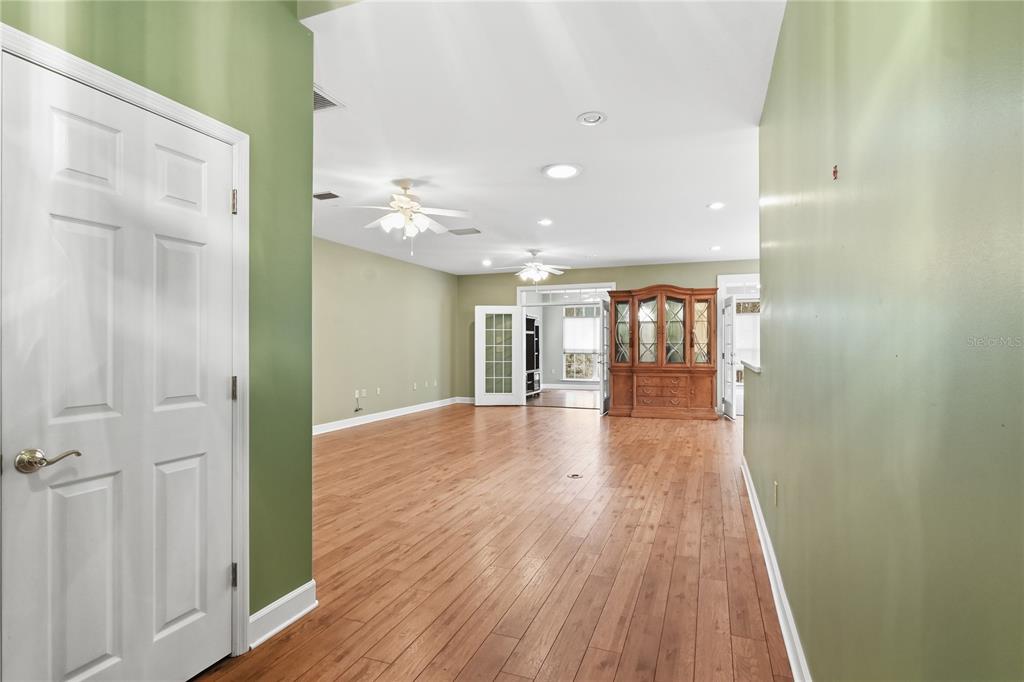 A spacious room with light green walls, wood flooring, and a large wooden hutch — 23378 LIVE OAK LANE, LIVE OAK, FL