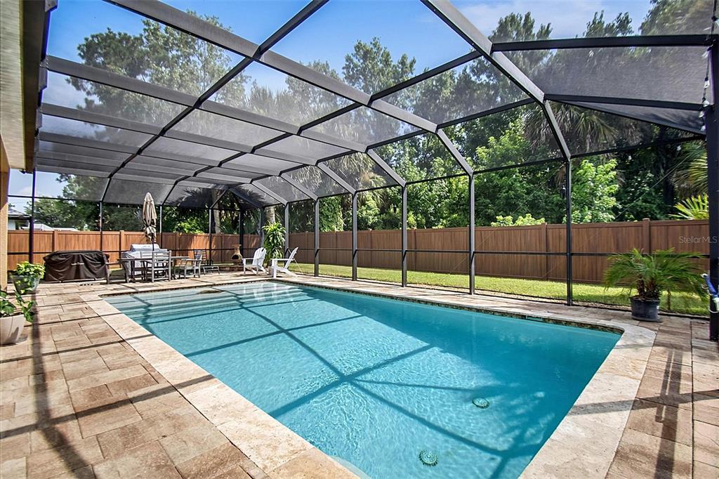 A rectangular swimming pool is enclosed by a screened lanai with a paver deck — 61 FRANCIS LN, PALM COAST, FL