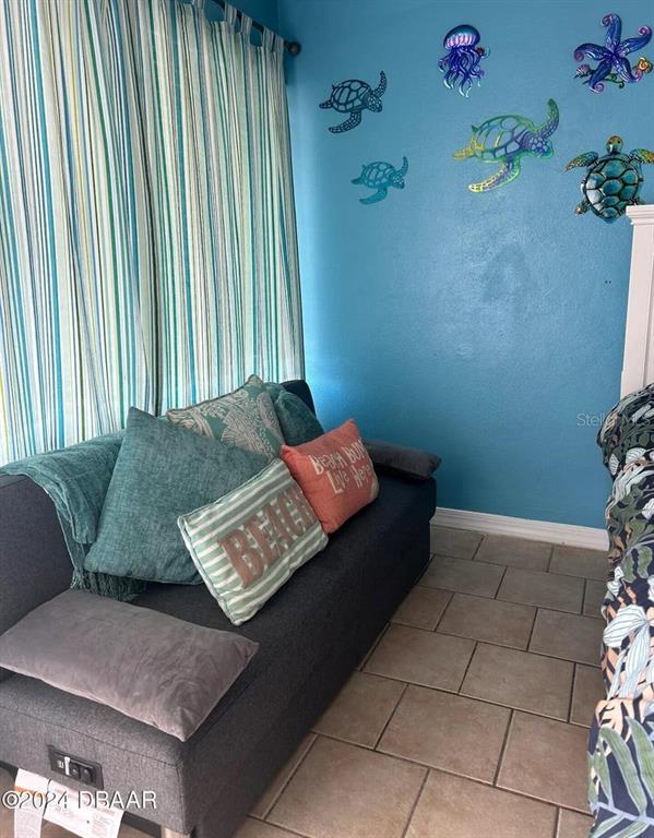 A gray sofa sits against a blue wall decorated with metal sea life figures — 219 S ATLANTIC AVENUE UNIT 308, DAYTONA BEACH, FL