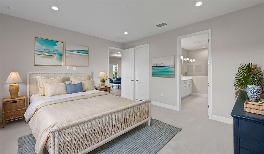 A bedroom features a wicker bed, a blue area rug, and an attached bathroom doorway — 2949 HERITAGE PINES DRIVE, FORT MYERS, FL