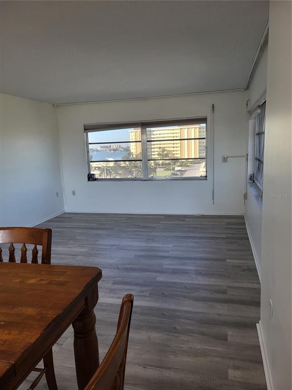 An empty room with gray wood-look flooring and a large window overlooking a waterfront view — 4650 COVE CIRCLE UNIT 611, ST PETERSBURG, FL