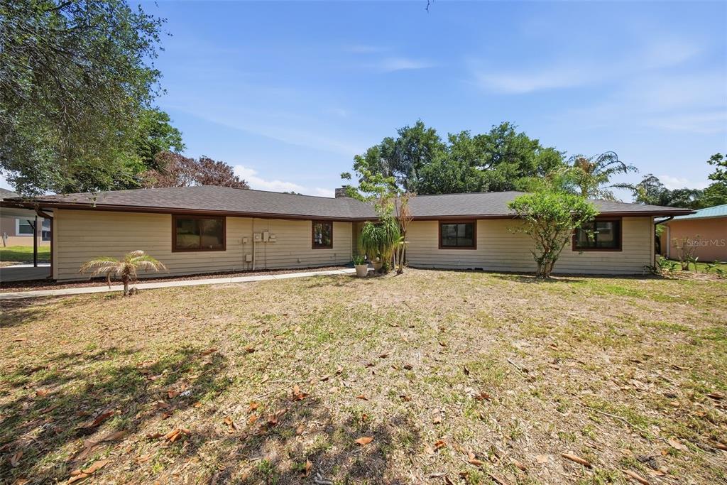 A single-story house with beige horizontal siding and a dark roof sits on a lot — 410 S RAMONA AVENUE, LAKE ALFRED, FL