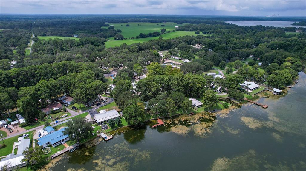 An aerial view shows houses nestled among trees along the shore of a large lake — 9065 W LAKEVIEW COURT, CRYSTAL RIVER, FL