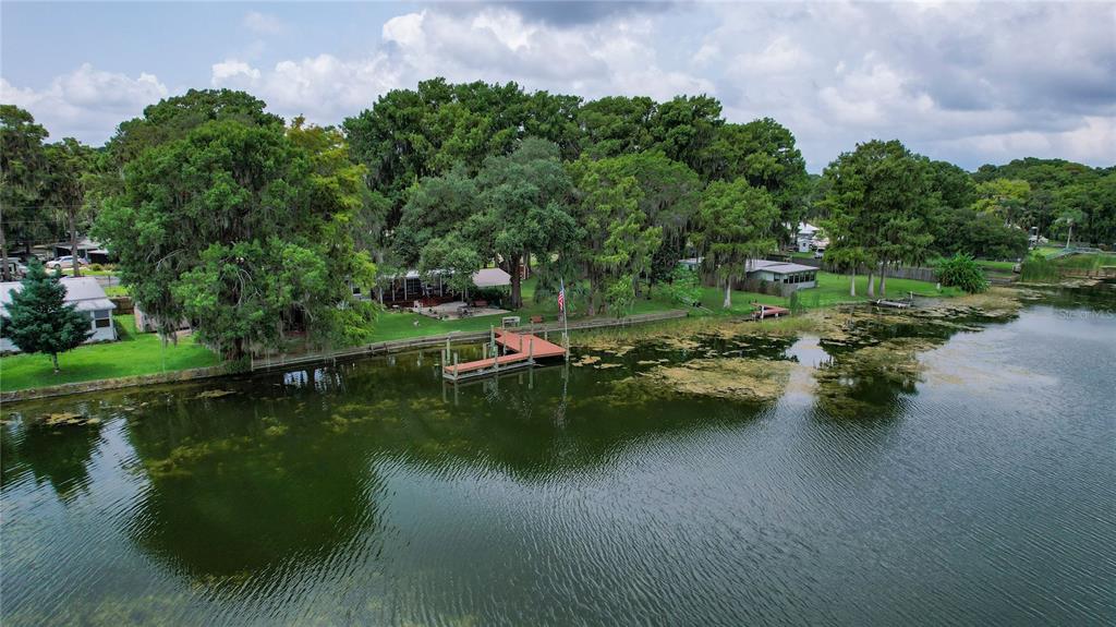An aerial view shows a house with a wooden dock on a tree-lined lake — 9065 W LAKEVIEW COURT, CRYSTAL RIVER, FL