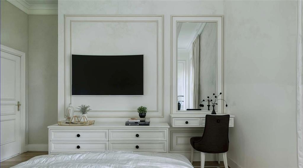 A bedroom features a white dresser, a wall-mounted television, and a built-in vanity with mirror — 12408 BATFISH COURT, PLACIDA, FL