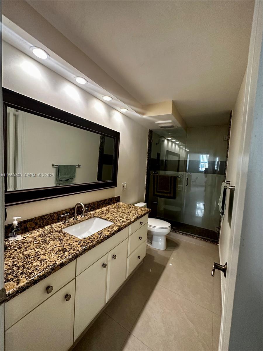 A bathroom features a granite countertop vanity, a large mirror, and a glass-enclosed shower — 1501 S Ocean Dr # 201, Hollywood FL 33019, HOLLYWOOD, FL