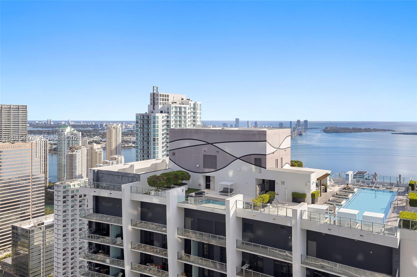 An elevated view of a high-rise building rooftop featuring a swimming pool and lounge area — 1000 Brickell Plz, Miami FL 33131, MIAMI, FL