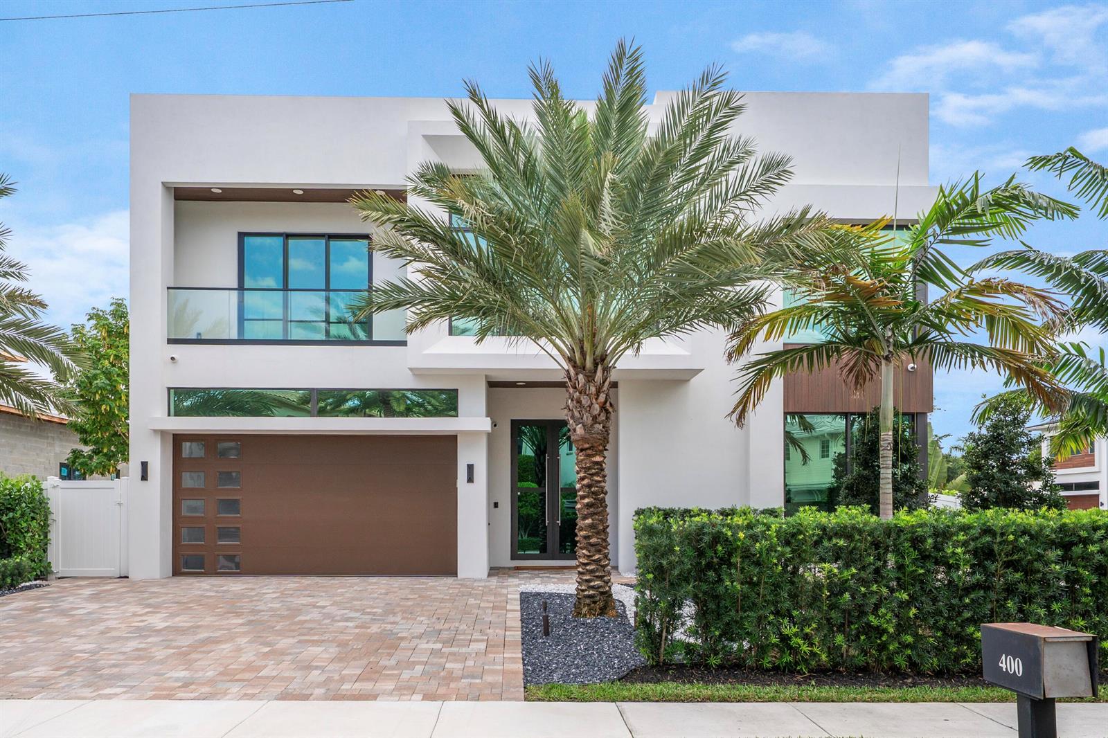 A modern two-story house features a brown garage door, glass balcony, and a palm tree — 400 NE 4th Street, Boca Raton FL 33432, BOCA RATON, FL