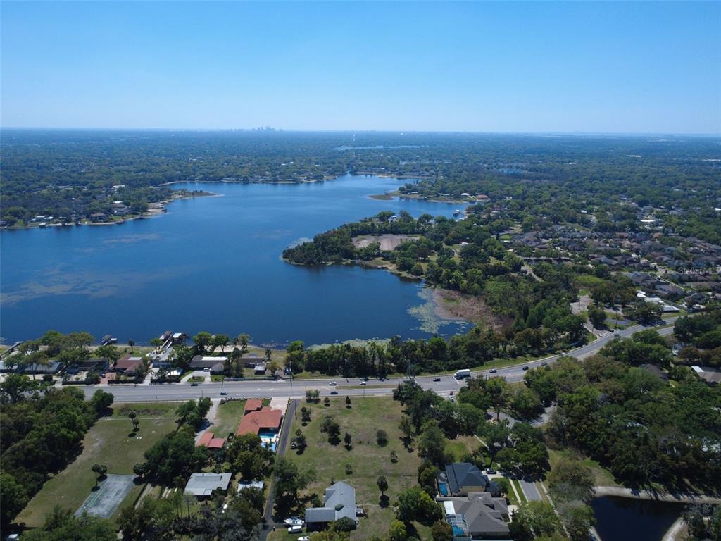 An aerial view shows a house with a dark roof, pool, and detached garage — 2125 W BEARSS AVENUE, TAMPA, FL