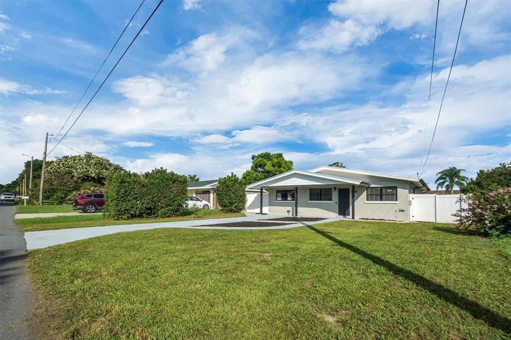 A single-story house with a light gray exterior, a covered entryway, and a concrete driveway — 1365 SHERIDAN STREET SW, WINTER HAVEN, FL