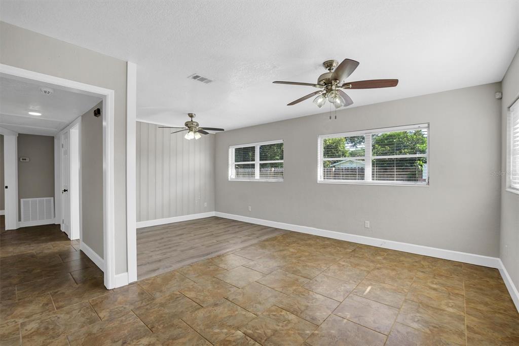 An interior view of a living area featuring tile flooring, grey walls, and ceiling fans — 1365 SHERIDAN STREET SW, WINTER HAVEN, FL