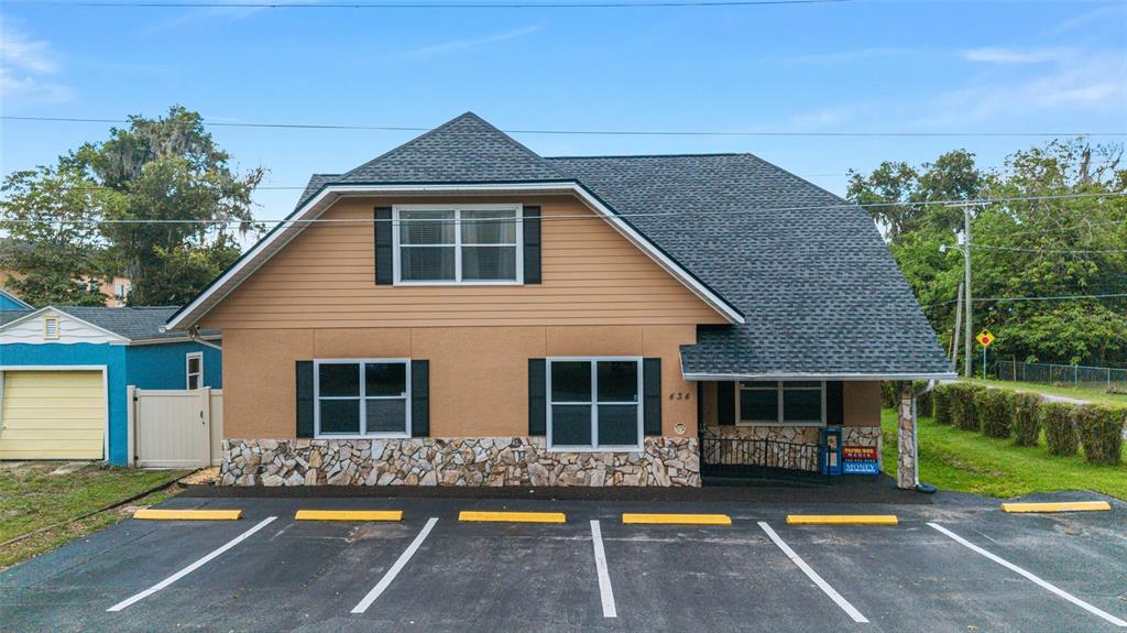 A two-story building with tan siding, stone accents, and a parking lot in front — 434 SW 14TH STREET, OCALA, FL