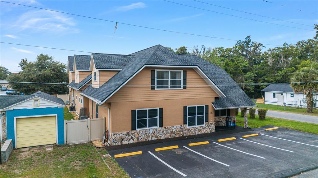 An exterior view shows a tan two-story building with a stone base and a parking lot — 434 SW 14TH STREET, OCALA, FL
