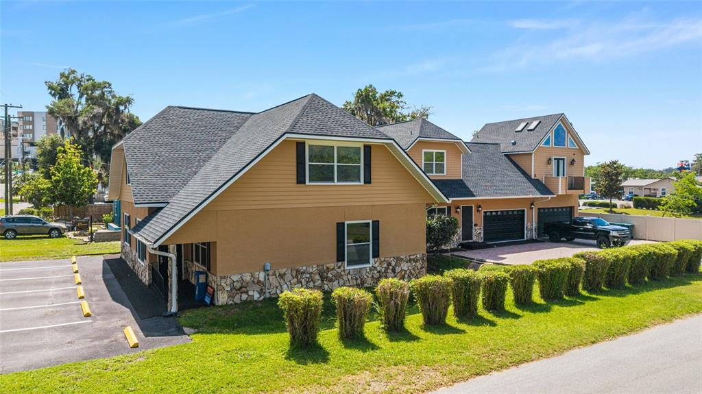 An exterior view of a two-story tan house with a stone base and parking lot — 434 SW 14TH STREET, OCALA, FL