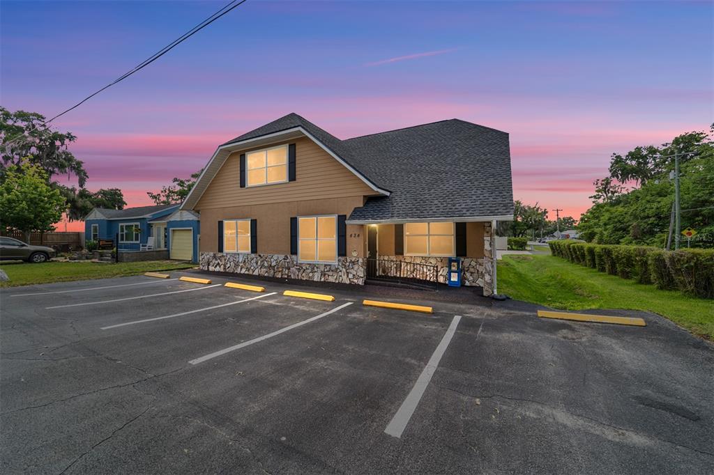 A two-story building with tan siding and stone veneer features a paved parking lot — 434 SW 14TH STREET, OCALA, FL