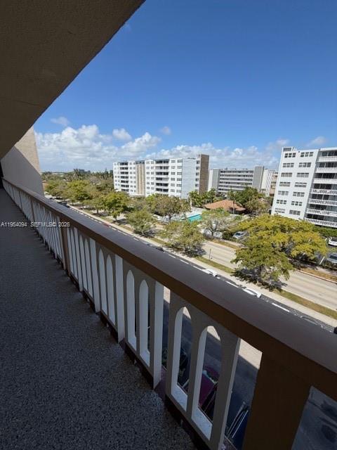 A balcony with a white railing overlooks a street, trees, and several apartment buildings — 319 NE 14th Ave # 607, Hallandale Beach FL 33009, HALLANDALE BEACH, FL