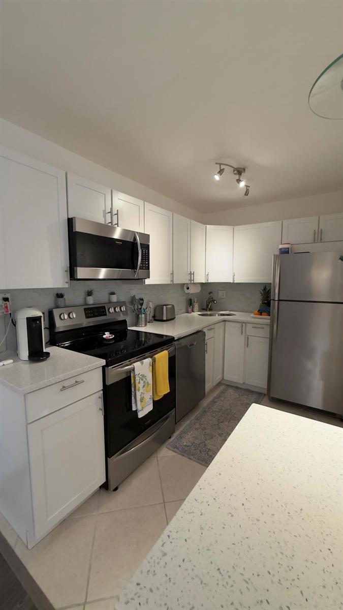 A kitchen with white cabinets, stainless steel appliances, and light-colored countertops — 702 SE 2nd Avenue SE # 405, Deerfield Beach FL 33441, DEERFIELD BEACH, FL