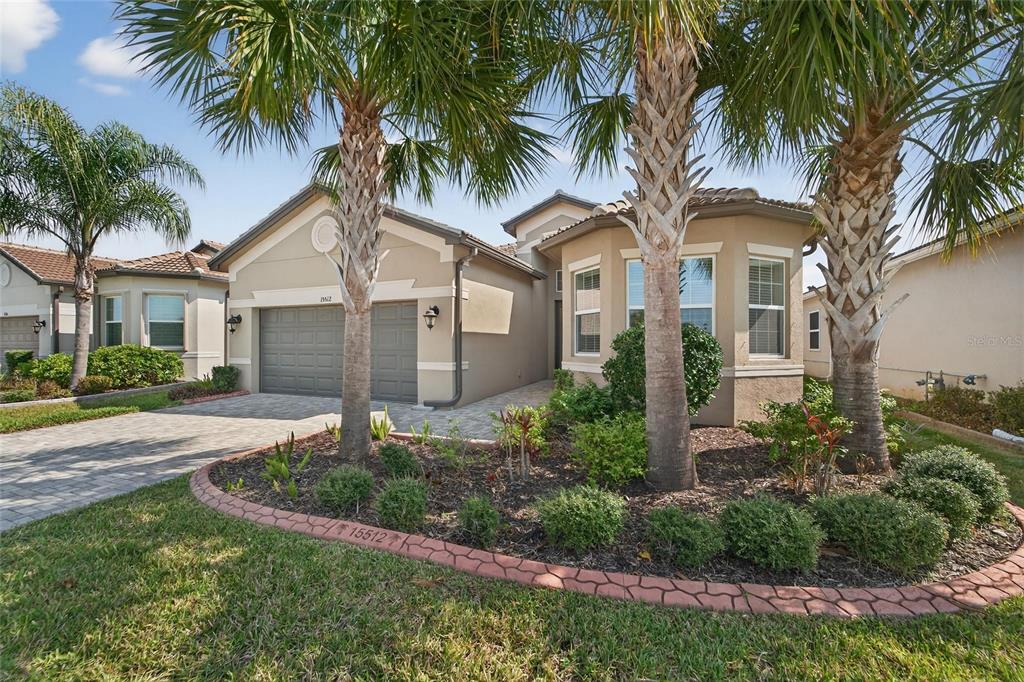 A single-story house with a two-car garage, palm trees, and a paved driveway — 15512 CORONA DEL MAR DRIVE, WIMAUMA, FL