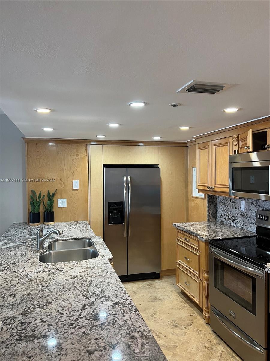 A kitchen features light wood cabinets, granite countertops, stainless steel appliances, and recessed lighting — 1717 N Bayshore Dr # 1856, Miami FL 33132, MIAMI, FL