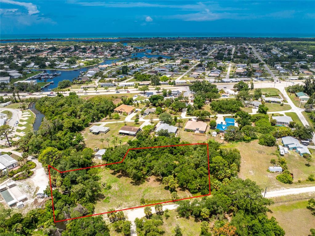 An aerial view shows a rectangular, tree-covered vacant lot outlined in red — 2ND STREET, ENGLEWOOD, FL