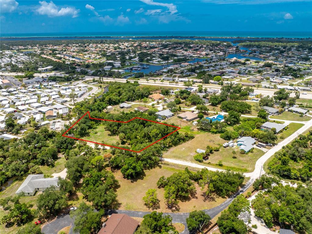 An aerial view shows a wooded, rectangular plot of land outlined in red — 2ND STREET, ENGLEWOOD, FL