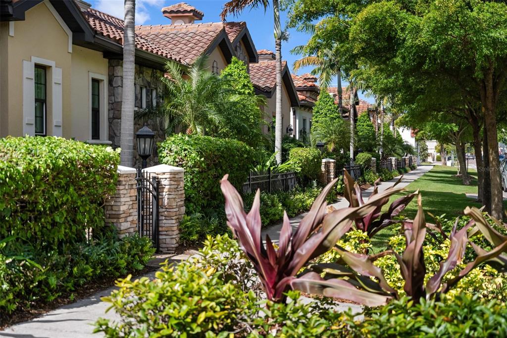 A sidewalk runs alongside a row of Mediterranean-style townhomes with stone accents and tile roofs — 134 E TAMPA AVENUE, VENICE, FL