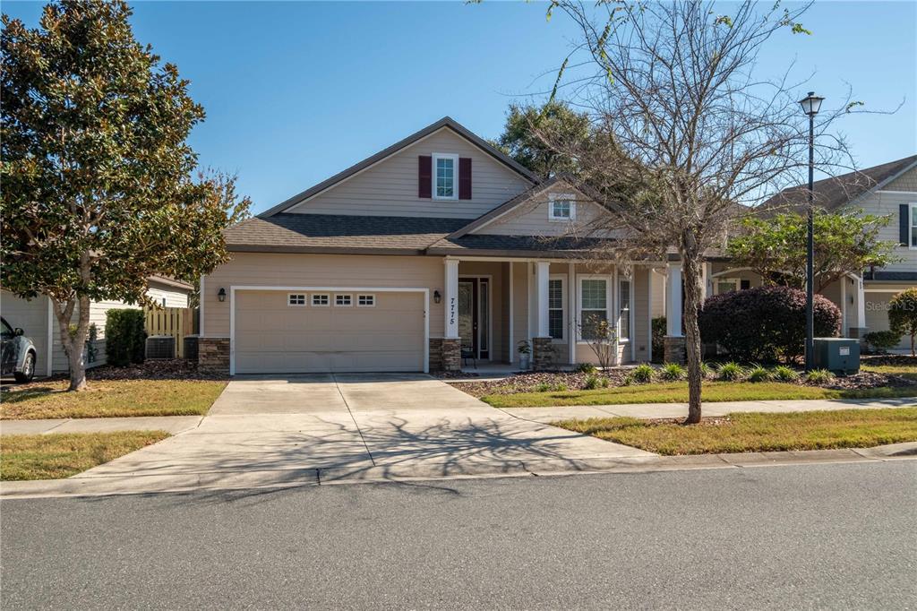 A single-story suburban house with a two-car garage and a covered front porch — 7775 SW 80TH DRIVE, GAINESVILLE, FL