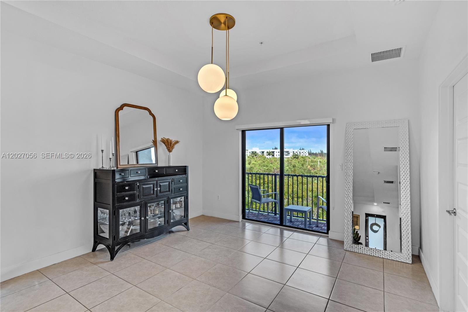 A dining room features a black sideboard, a floor mirror, and a modern pendant light — 8175 NW 104th Ave # 32, Doral FL 33178, DORAL, FL