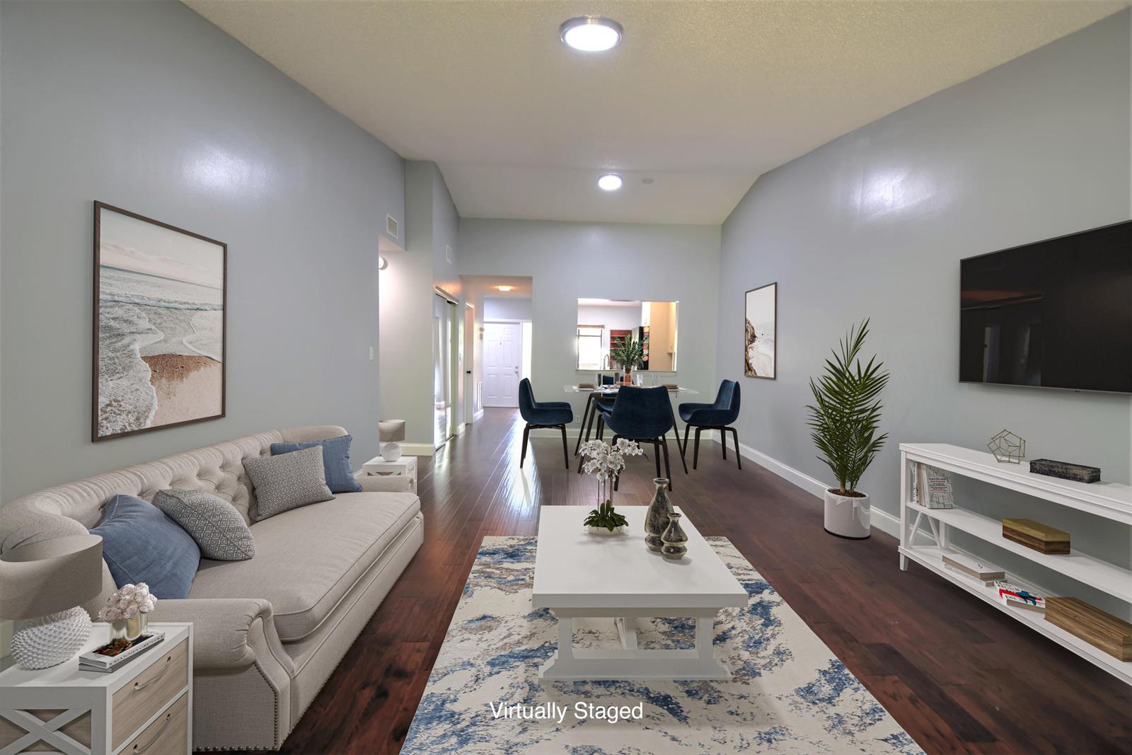 This is a virtually staged living and dining room with light blue walls and hardwood floors — 5087 Oakhill Lane, Delray Beach FL 33484, DELRAY BEACH, FL