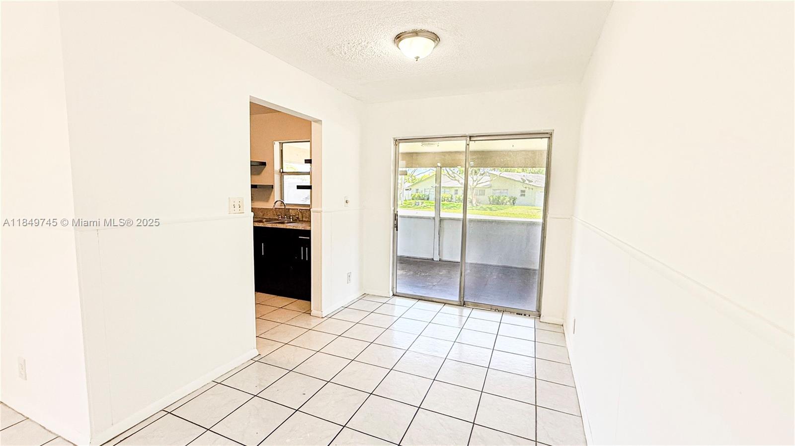 A dining area with white walls, tile flooring, and sliding glass doors leading to a patio — 3200 NW 5th Ter # 8, Pompano Beach FL 33064, POMPANO BEACH, FL