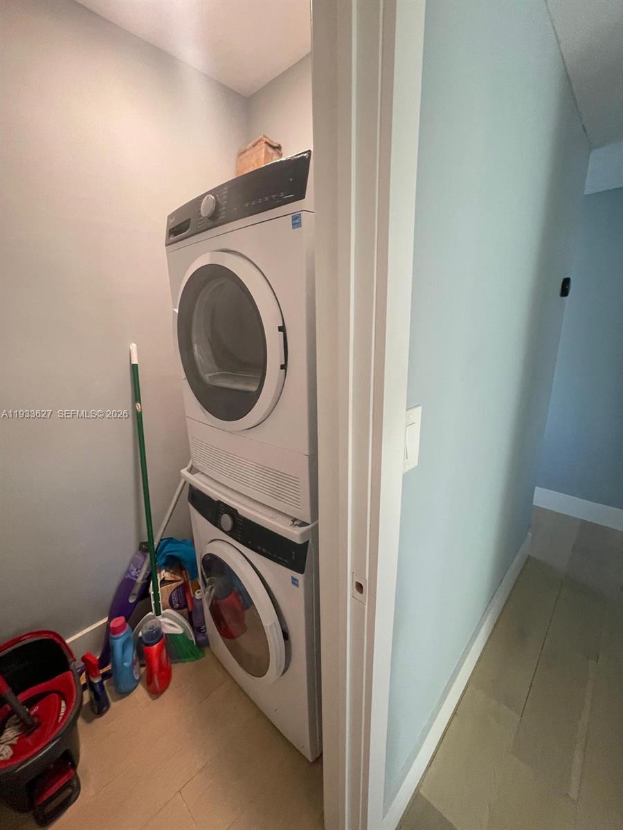 A walk-in closet features white shelving, drawers, a hanging rod, and light wood-look flooring — 1235 Pennsylvania Ave # 4E, Miami Beach FL 33139, MIAMI BEACH, FL