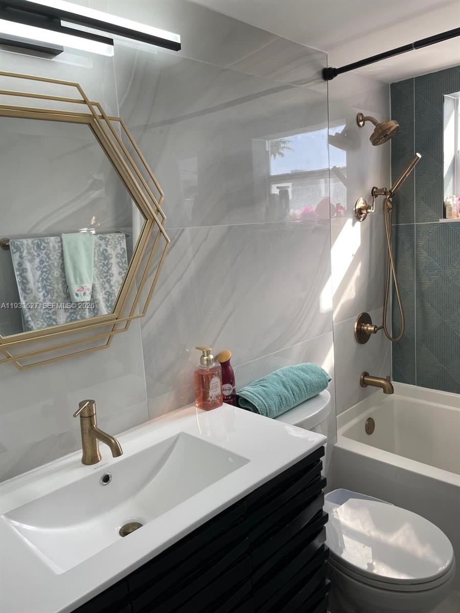 A stacked washer and dryer unit is located in a small laundry closet — 1235 Pennsylvania Ave # 4E, Miami Beach FL 33139, MIAMI BEACH, FL